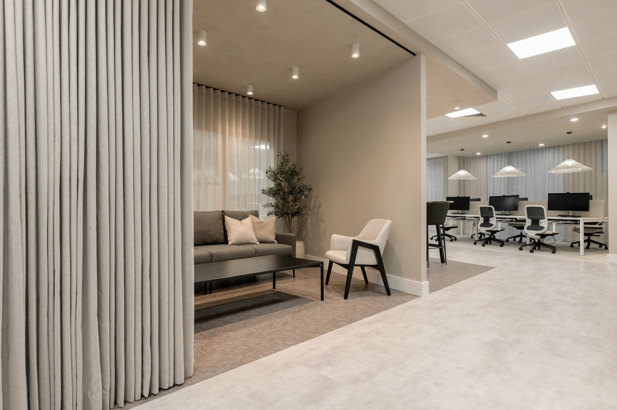 Apatura Energy breakout nook behind a curtain divider, opening onto an open-plan desk floor, designed and built by Building Interiors