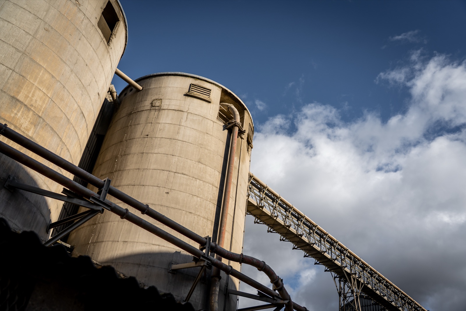 Cement silos and a conveyor gantry at Breedon, seen from below against the sky