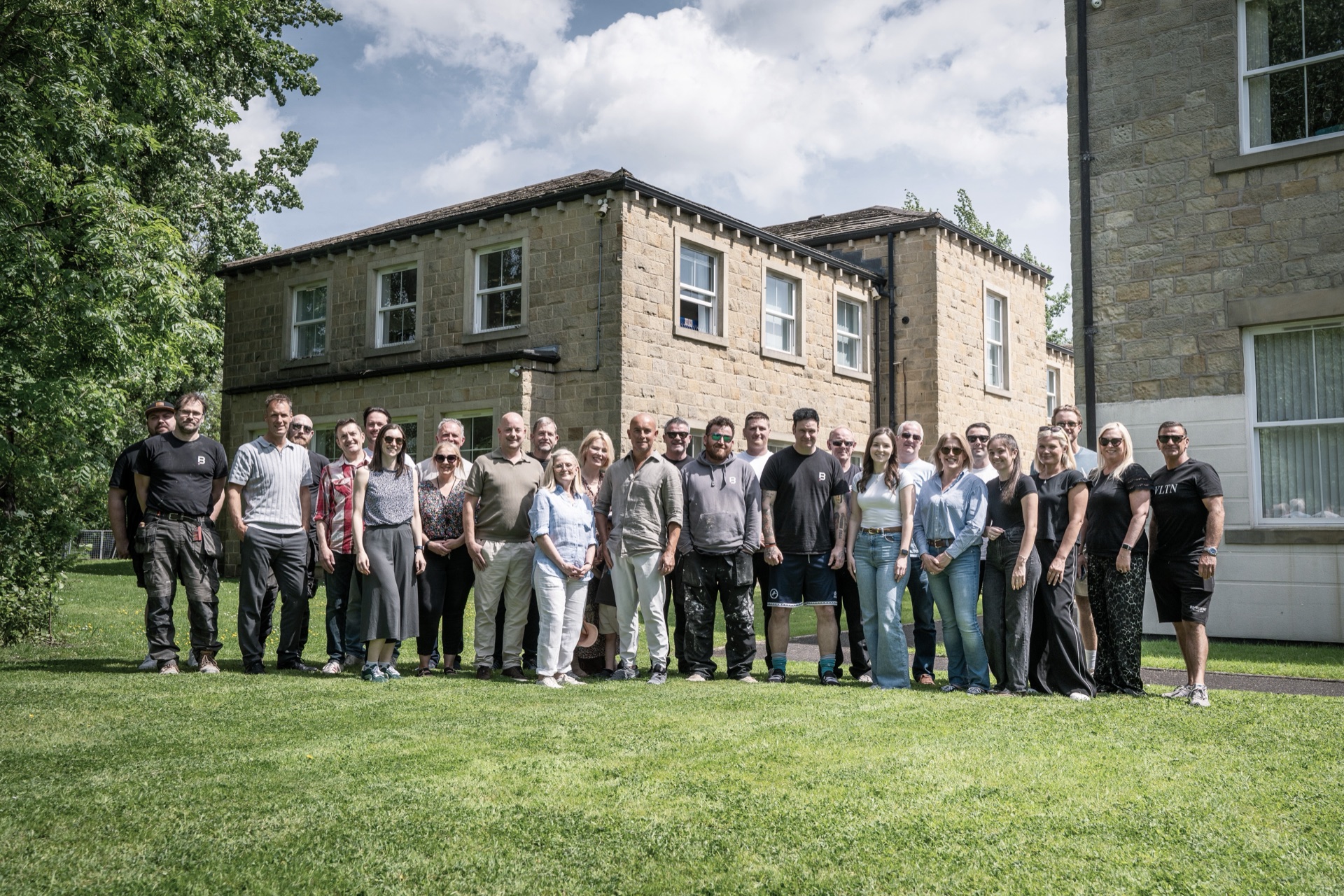 The Building Interiors team gathered on the lawn outside their stone-built offices