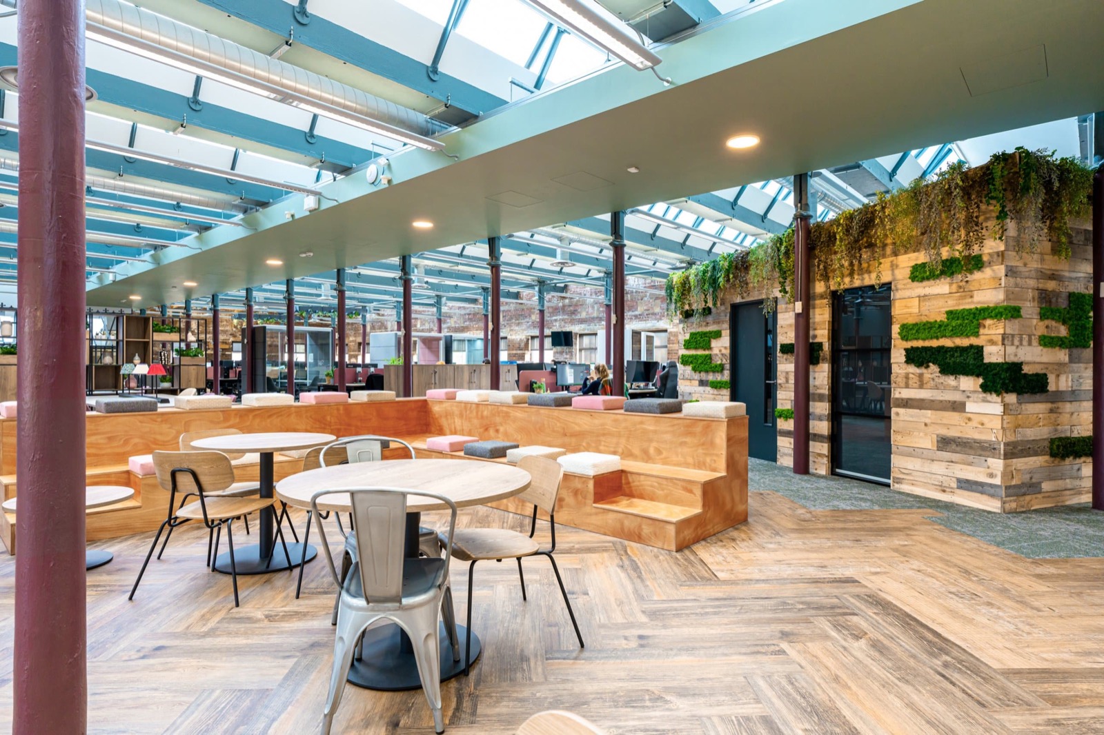 Bespoke shelving and dining furniture at Prestige Gifting, styled with lamps and planting beneath a glazed roof