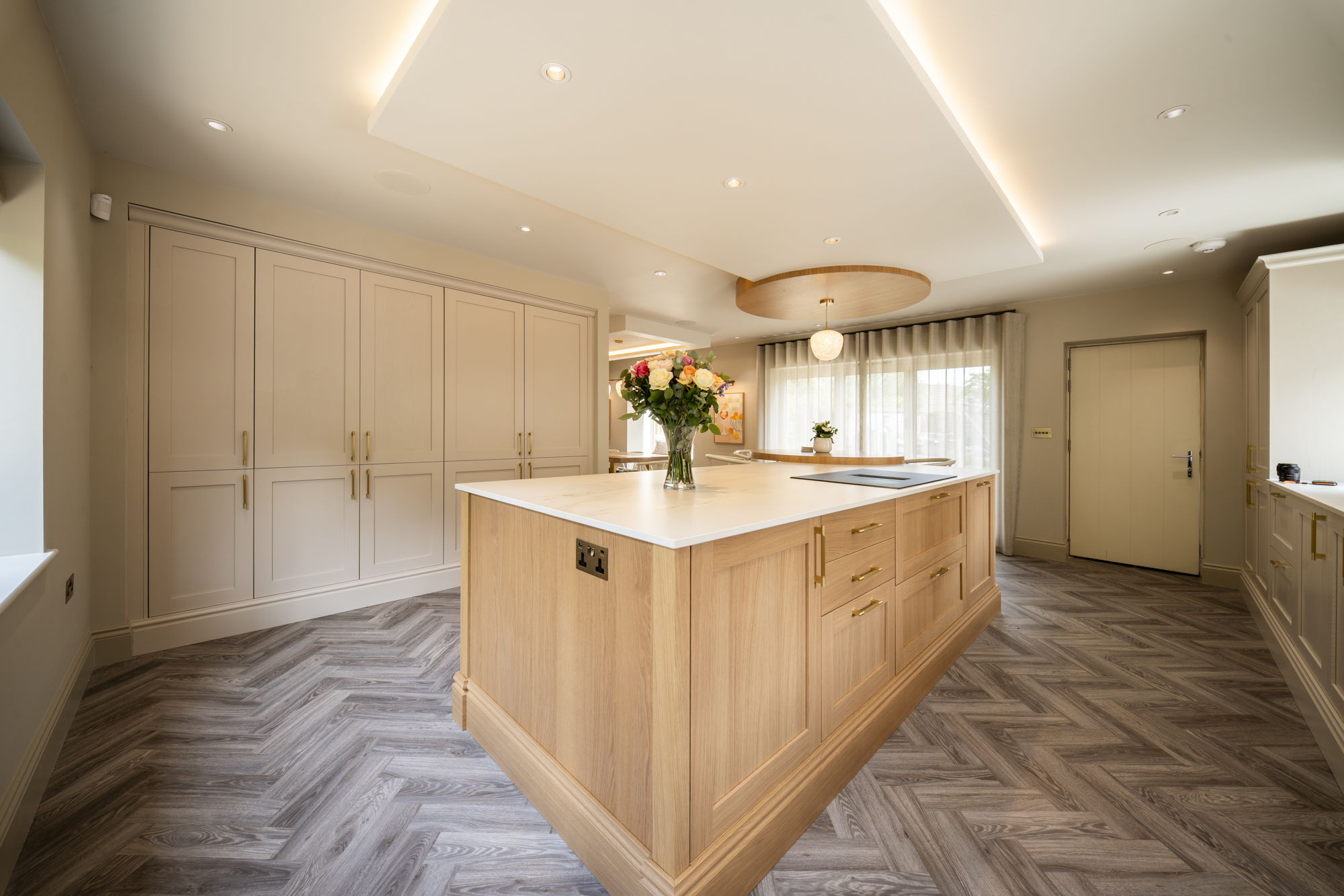 Whole-home renovation at Well House — oak kitchen island with a run of fitted shaker cabinetry